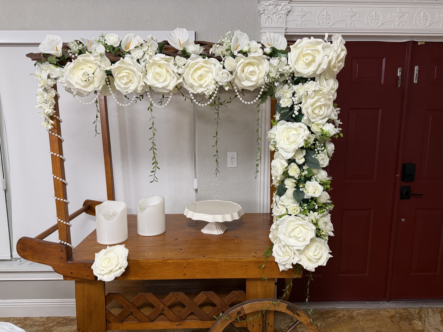 Wooden event cart with white roses, pearl accents, candles and a dessert stand
