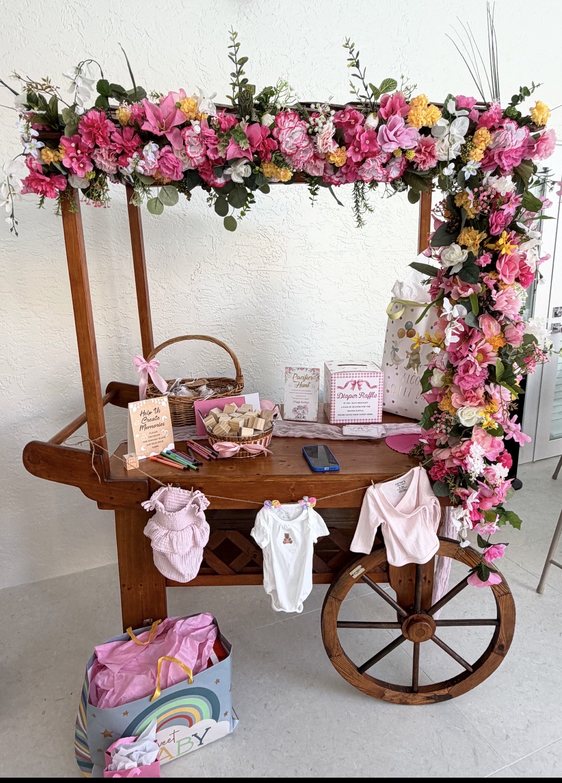 Same wooden cart with bright pink and yellow flowers at a baby shower