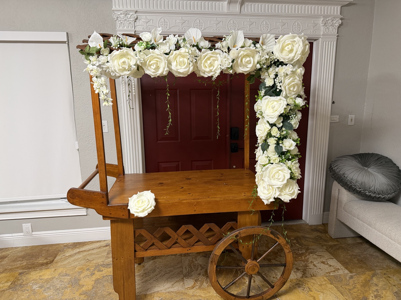 Wooden event cart decorated with white roses and greenery